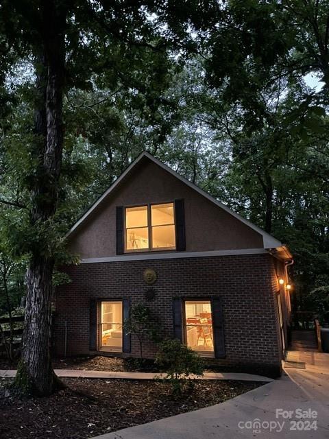 exterior space featuring brick siding and stucco siding