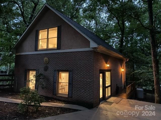 rear view of property with brick siding and stucco siding