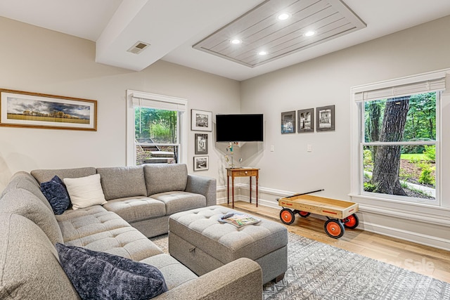 living room with recessed lighting, visible vents, baseboards, and wood finished floors