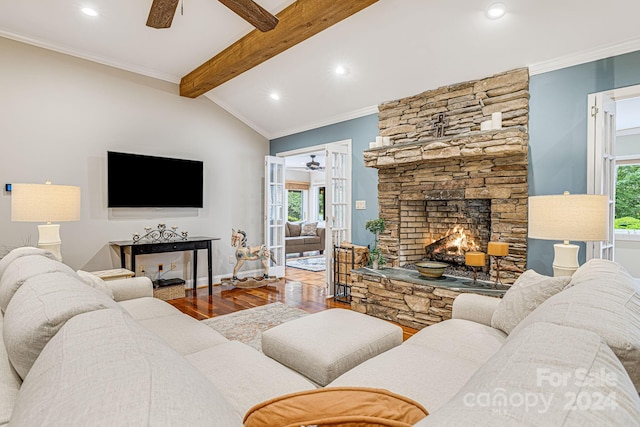 living room with plenty of natural light, wood finished floors, a fireplace, and crown molding