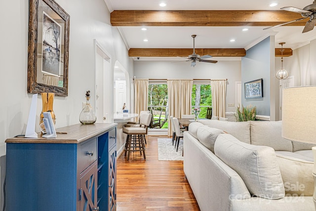 living room featuring a ceiling fan, light wood-style flooring, recessed lighting, crown molding, and beamed ceiling