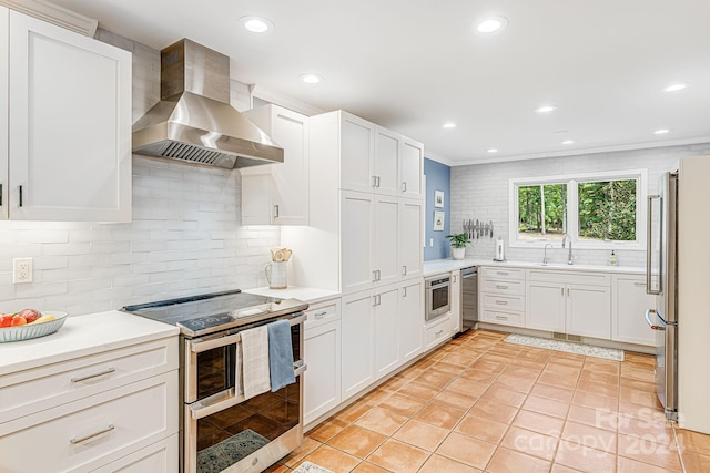 kitchen featuring white cabinetry, appliances with stainless steel finishes, wall chimney exhaust hood, light countertops, and light tile patterned floors