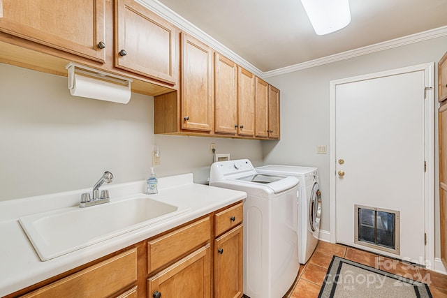 laundry area featuring crown molding, washing machine and dryer, light tile patterned flooring, cabinet space, and a sink