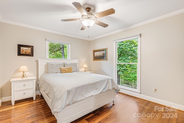 bedroom featuring crown molding, wood finished floors, baseboards, and ceiling fan