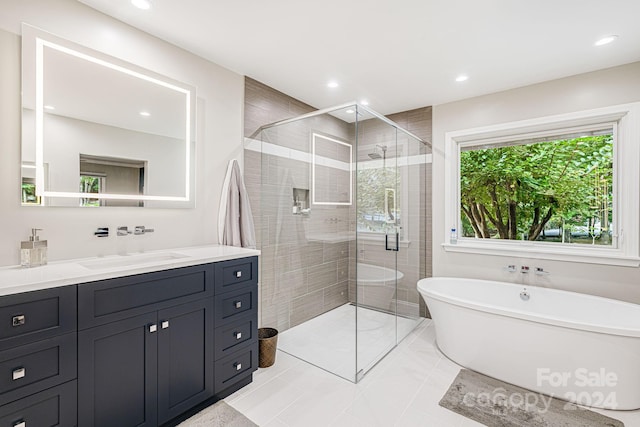 full bath featuring vanity, a freestanding tub, recessed lighting, and a stall shower