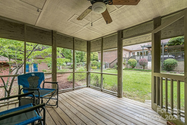 unfurnished sunroom with ceiling fan