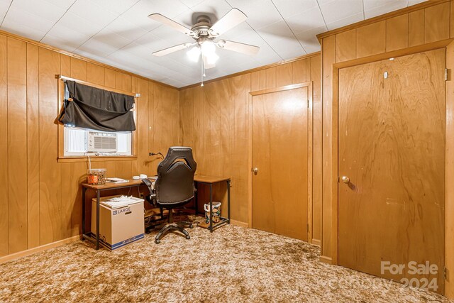 office area featuring carpet flooring, wood walls, and ceiling fan