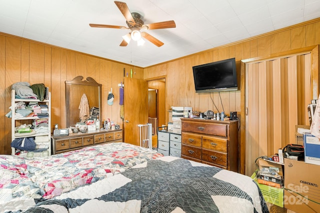 bedroom with wood walls and ceiling fan