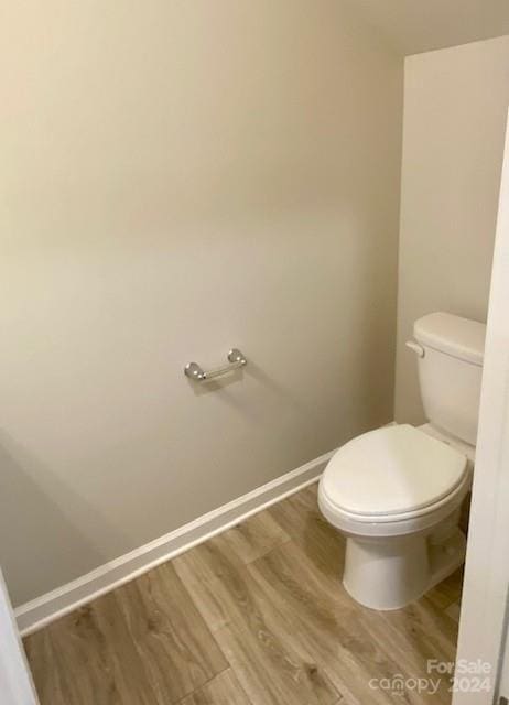 bathroom with wood-type flooring and toilet