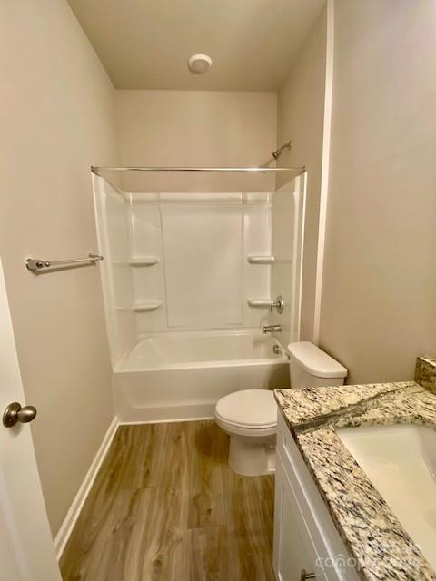 full bathroom featuring shower / bath combination, vanity, hardwood / wood-style floors, and toilet