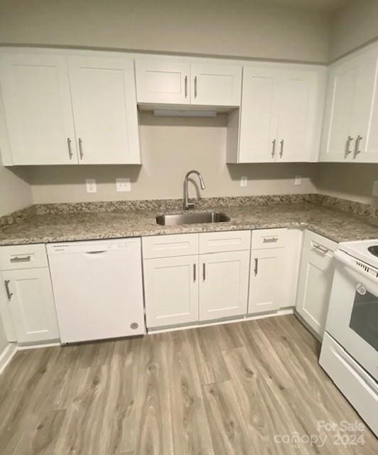 kitchen featuring sink, white appliances, white cabinetry, dark stone countertops, and light wood-type flooring