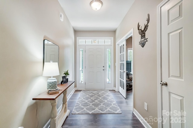 entrance foyer with dark wood-type flooring and baseboards