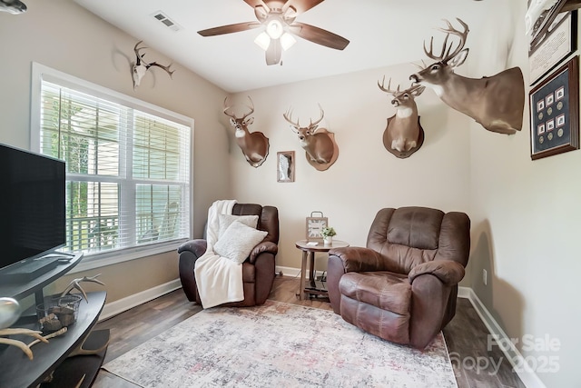 sitting room with ceiling fan, visible vents, and baseboards