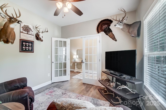 living area featuring ceiling fan, french doors, wood finished floors, and baseboards