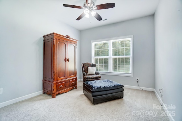 living area with a ceiling fan, visible vents, light carpet, and baseboards