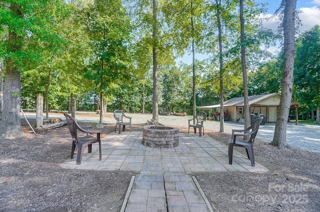 view of community with a fire pit and a patio area