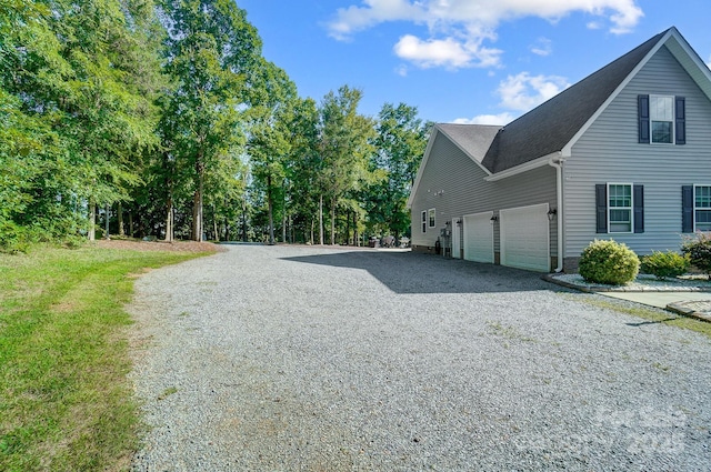 view of side of home featuring a garage and driveway