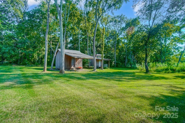 view of yard featuring a carport, an outbuilding, and an outdoor structure