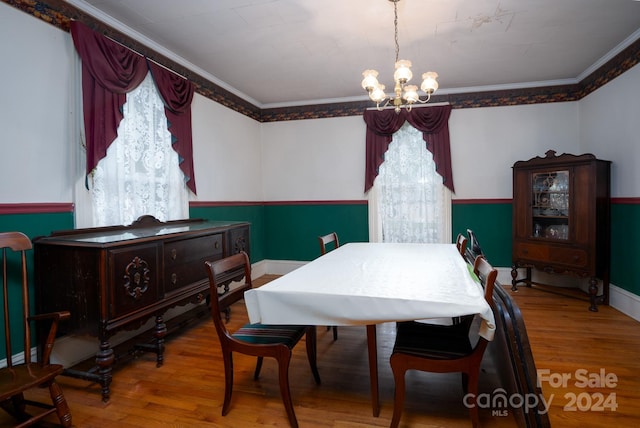 dining room featuring hardwood / wood-style floors, a wealth of natural light, and ornamental molding