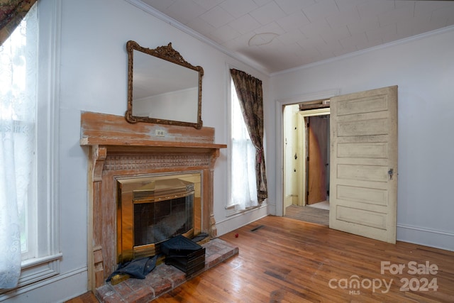 unfurnished living room with crown molding and hardwood / wood-style flooring