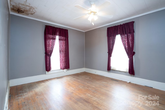 empty room with ceiling fan, wood-type flooring, and ornamental molding