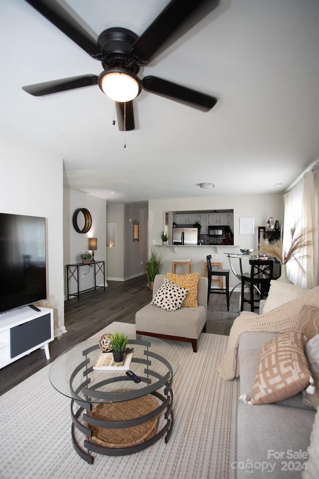 living room with ceiling fan and dark hardwood / wood-style flooring