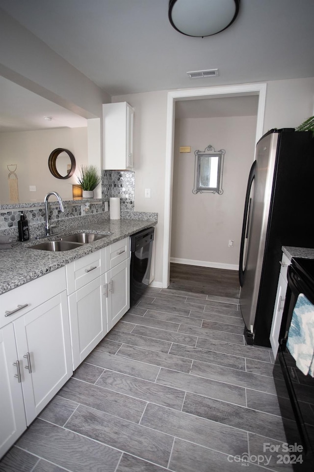 kitchen featuring white cabinets, sink, light stone countertops, and black appliances