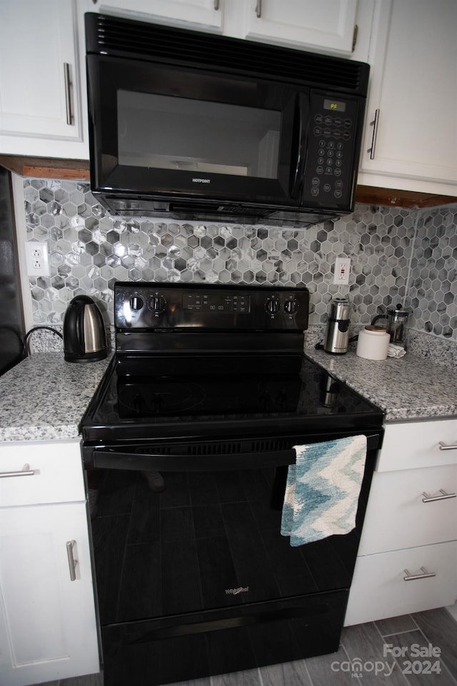 kitchen with white cabinetry, black appliances, decorative backsplash, and light stone countertops