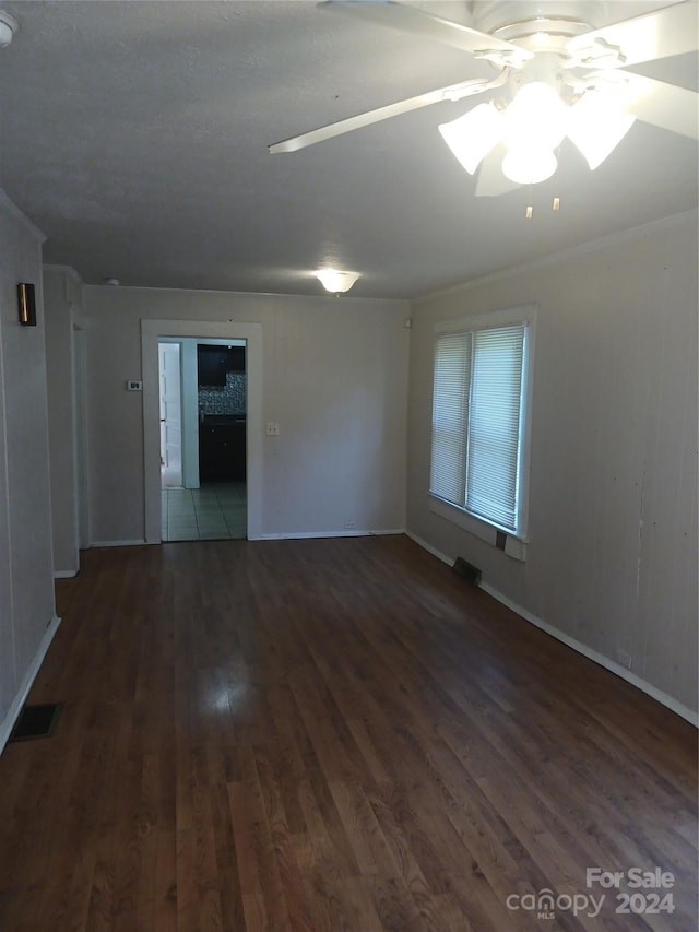 unfurnished room featuring ceiling fan, ornamental molding, and dark hardwood / wood-style floors