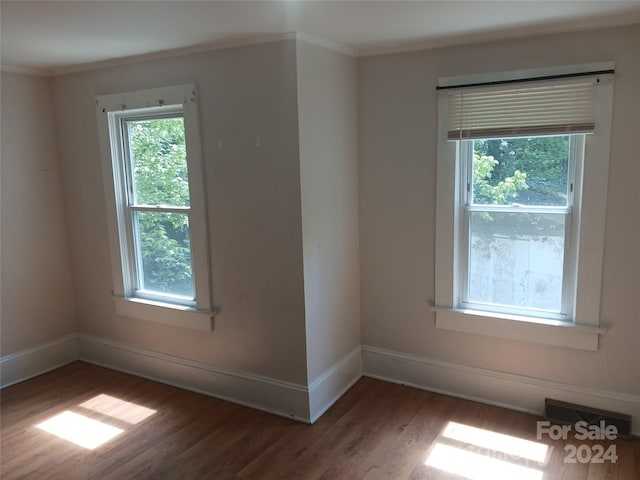 unfurnished room with dark hardwood / wood-style flooring and ornamental molding