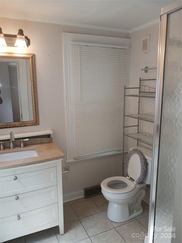 bathroom featuring vanity, tile patterned flooring, crown molding, and toilet