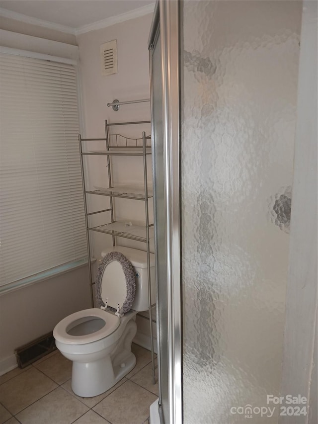 bathroom featuring tile patterned flooring, an enclosed shower, ornamental molding, and toilet