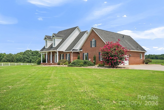 cape cod home featuring brick siding, a front yard, and fence