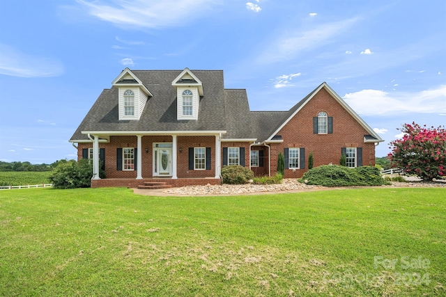 view of front of house featuring roof with shingles, a front lawn, and brick siding