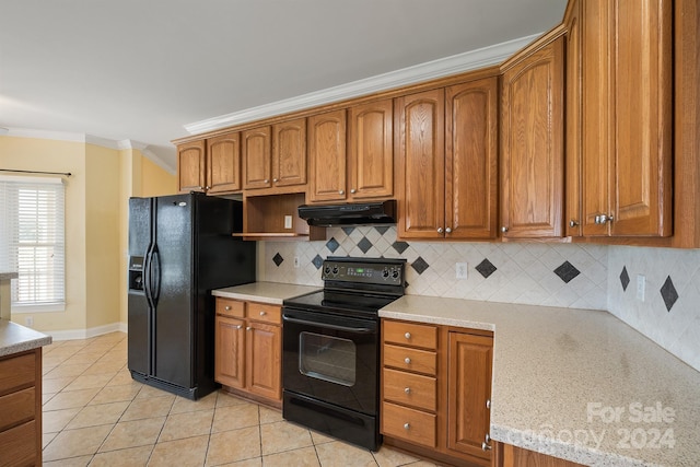 kitchen featuring ornamental molding, brown cabinetry, under cabinet range hood, and black appliances