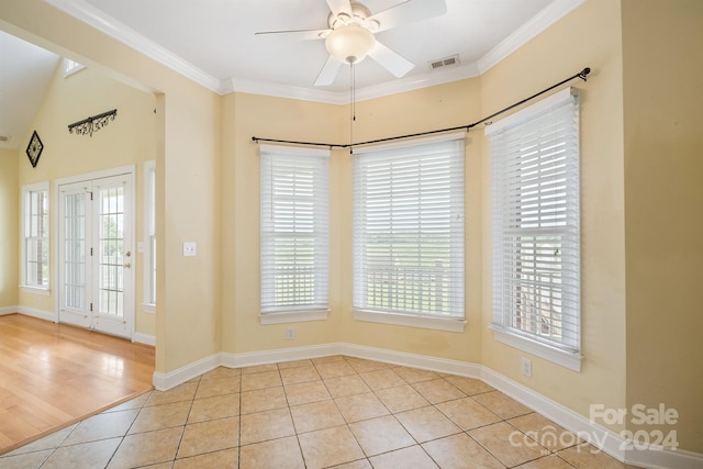 entrance foyer with ornamental molding, a ceiling fan, plenty of natural light, and tile patterned floors