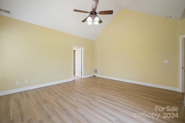 unfurnished room with high vaulted ceiling, light wood-type flooring, visible vents, and baseboards