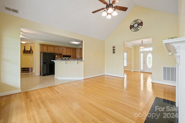 unfurnished living room with light wood finished floors, a ceiling fan, visible vents, and high vaulted ceiling