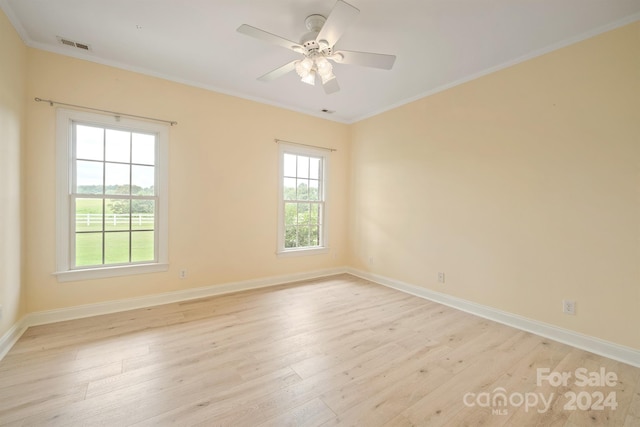 unfurnished room with light wood-style floors, a wealth of natural light, and visible vents