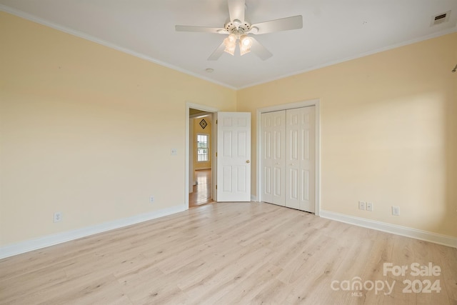 spare room featuring baseboards, visible vents, a ceiling fan, crown molding, and light wood-style floors