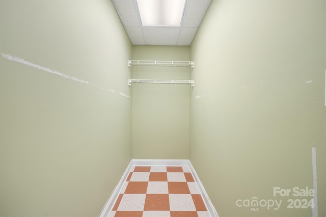 walk in closet featuring a drop ceiling and tile patterned floors