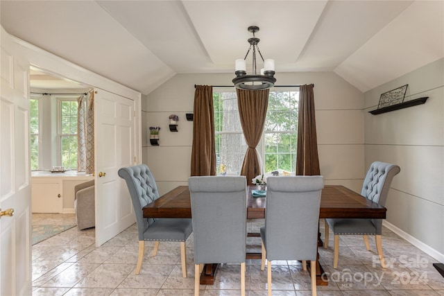 tiled dining space featuring a notable chandelier and vaulted ceiling