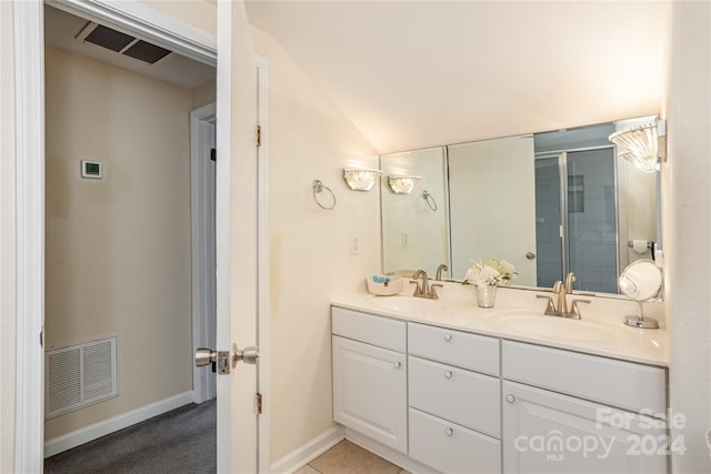 bathroom featuring double vanity and lofted ceiling