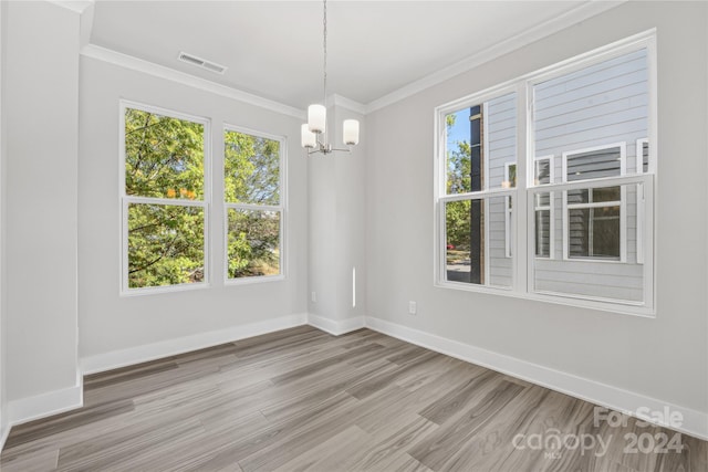 unfurnished dining area featuring hardwood / wood-style floors, a healthy amount of sunlight, and a chandelier