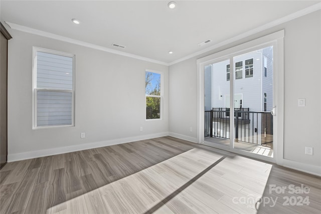 unfurnished room with light wood-type flooring and ornamental molding