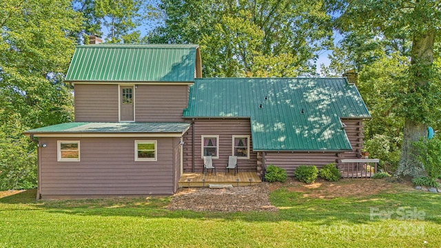 rear view of property with a yard and a wooden deck