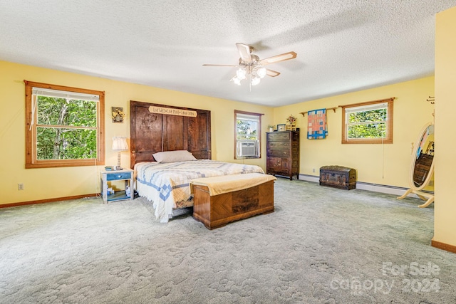 carpeted bedroom featuring multiple windows, ceiling fan, a baseboard radiator, and a textured ceiling