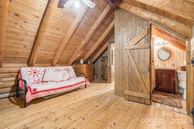 unfurnished bedroom with wooden walls, lofted ceiling with beams, ensuite bath, light wood-type flooring, and wood ceiling