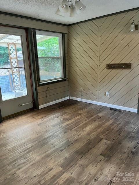 unfurnished room with ceiling fan, a textured ceiling, baseboards, and wood finished floors