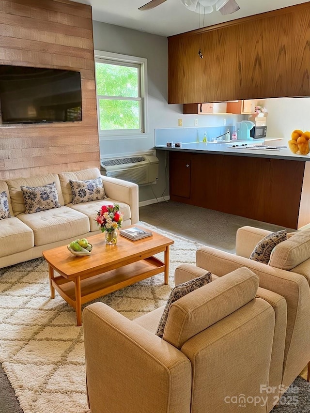 living area featuring a wall mounted air conditioner and ceiling fan